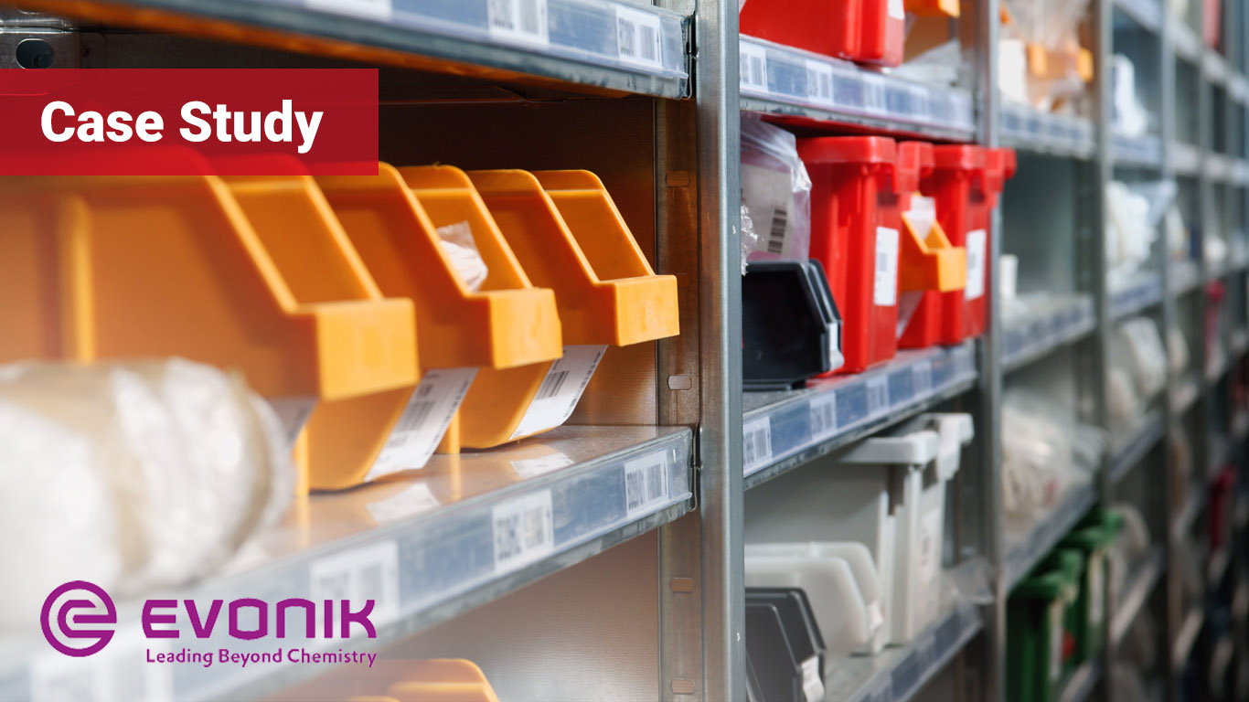Storage bins and racks in a warehouse with Evonik logo in the bottom left corner